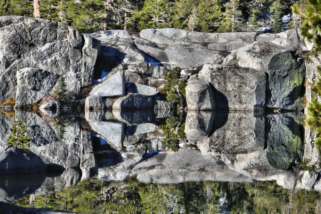 Mountain lake reflection of rock cliff overlook